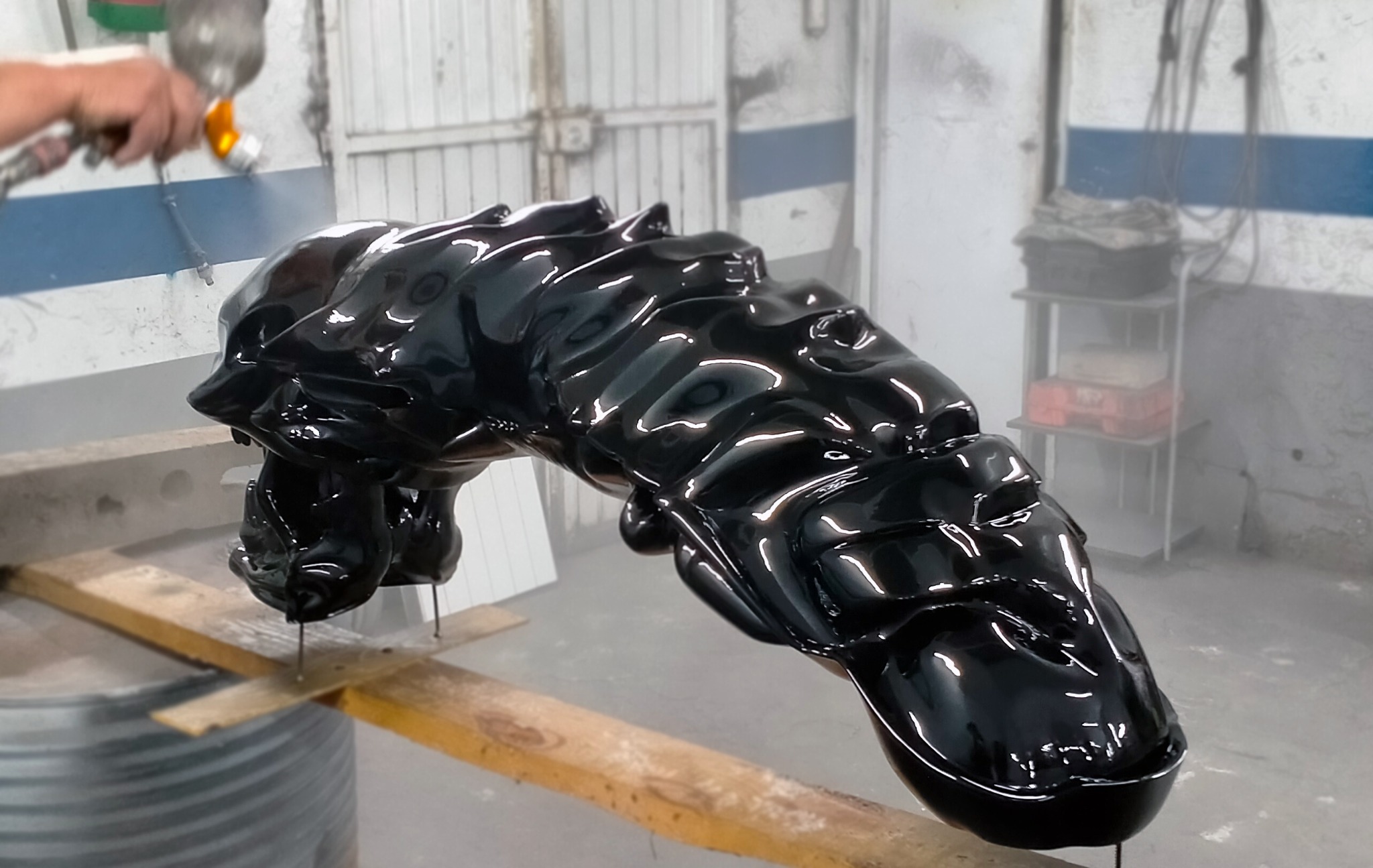 Aplicación con pistola del acabado negro brillante sobre la escultura Alien